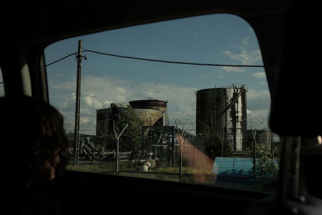 Industrial oil storage tanks seen through the van window during field transit. Photo courtesy of the artist